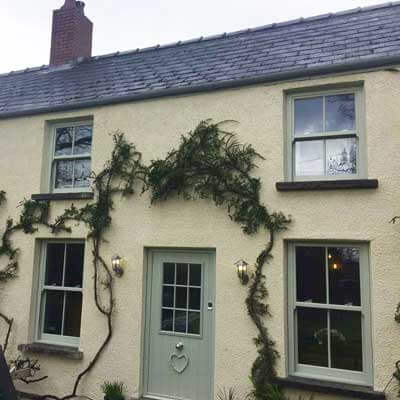 Chartwell green sash windows on cream house