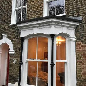 a white sash window on the ground floor seen from outside