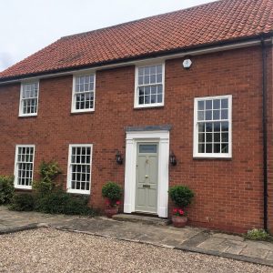 white ultimate rose sash windows on red brick house