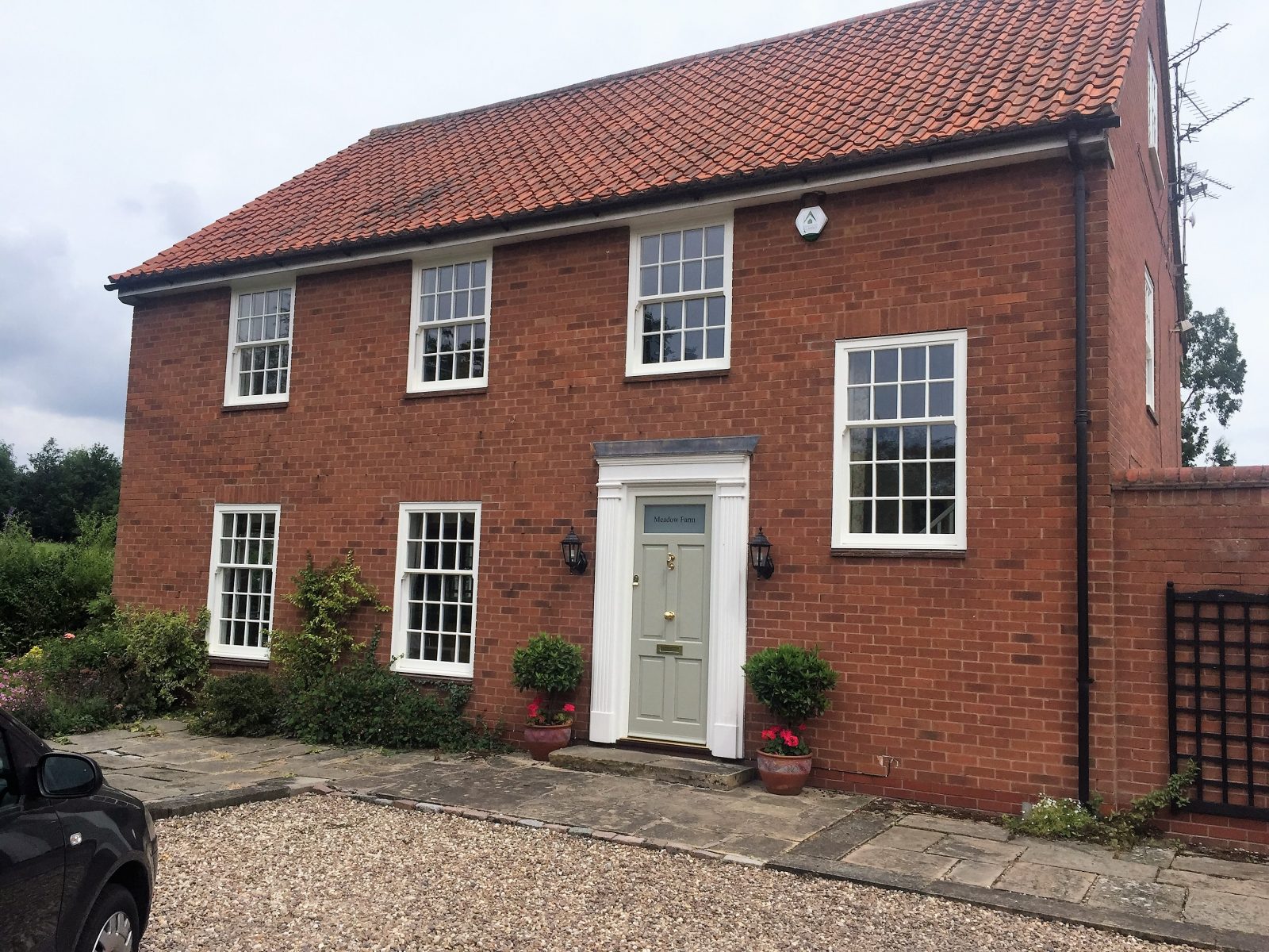 white ultimate rose sash windows on red brick house